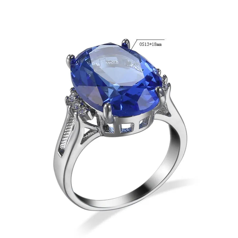 Blue black geometric ellipse shaped copper ring with an electroplated finish on a hand.