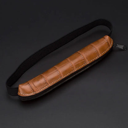 Long beige grey PU leather pencil case on a desk with pens