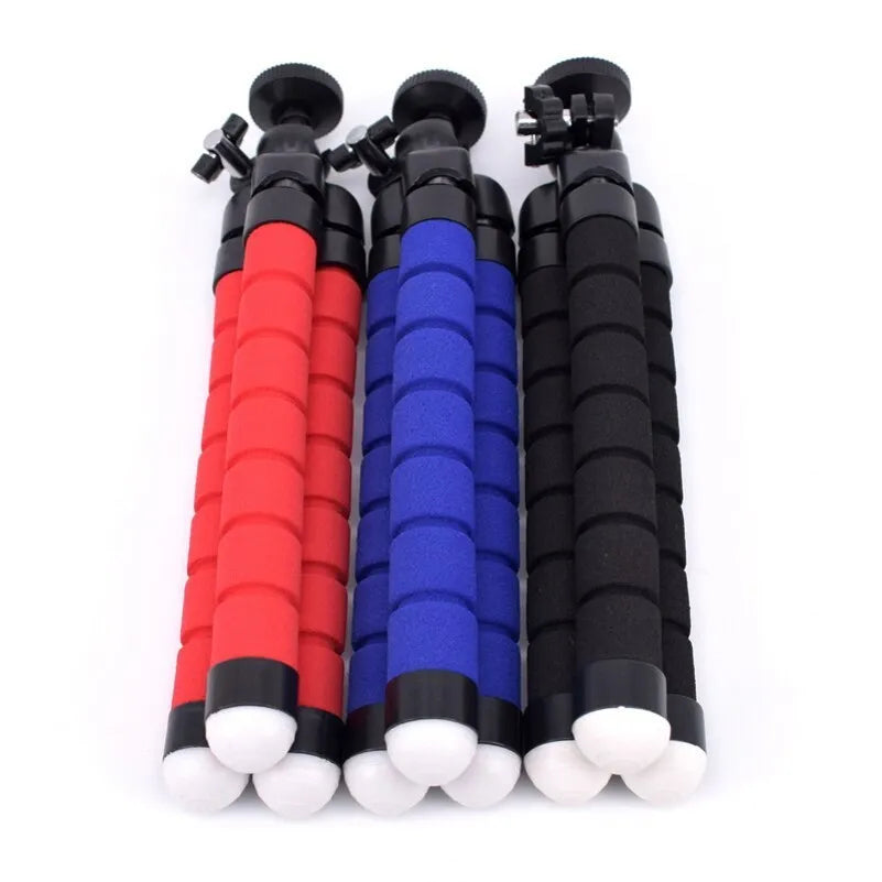 Black flexible octopus tripod with legs wrapped around a pole, holding a smartphone with a clip mount.