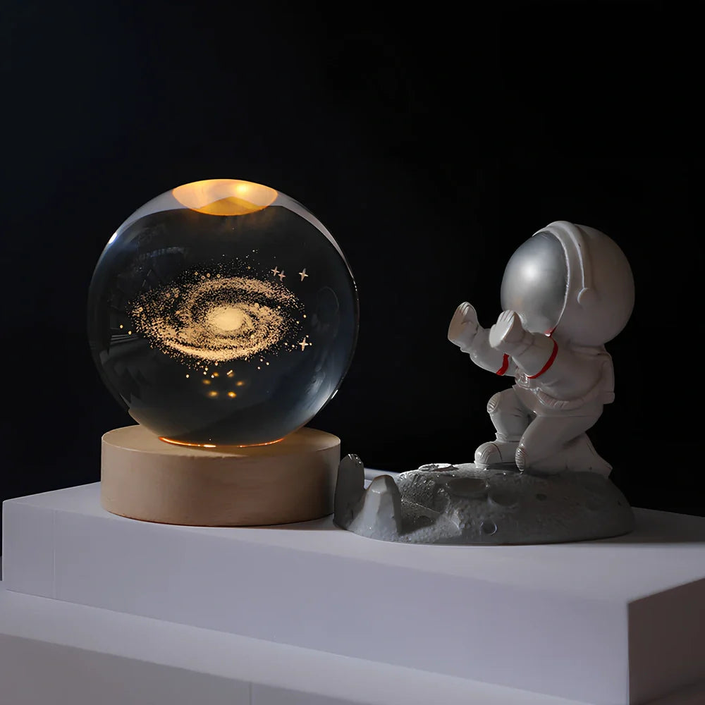 Cosmos Series crystal ball night light with wooden base and astronaut figure, showing Milky Way light pattern