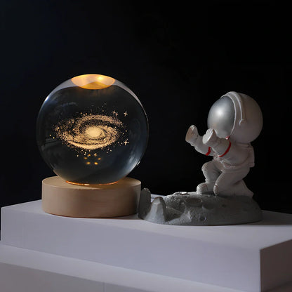Cosmos Series crystal ball night light with wooden base and astronaut figure, showing Milky Way light pattern
