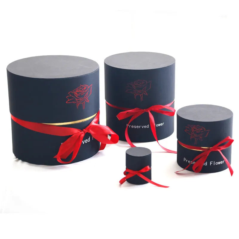 Luxury gift box containing an arrangement of preserved red eternal roses on a dark background.