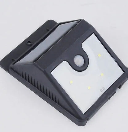 Solar 4 LED sensor light mounted on wall, showing solar panel and motion detector