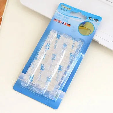 Self-adhesive plastic cable organiser clips in various colours holding a bundle of wires against a wall.