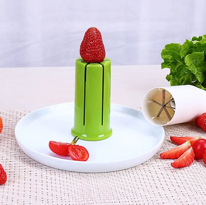 White ABS plastic kitchen slicer with six visible stainless steel blades for cutting cucumbers, carrots, and strawberries.