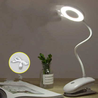 A modern white clip-on rechargeable desk lamp with a touch-sensitive switch and a plastic shade.