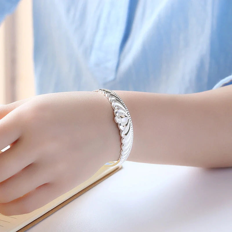 A close-up view of the elegant Crown Bracelet, showcasing its intricate crown-shaped design and shiny, rhodium-plated finish.
