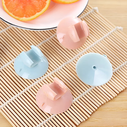 Blue PVC utensil holder with suction cup mounting a rice spoon on kitchen tiles