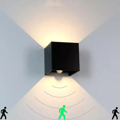 Compact square aluminium wall lamp with 360-degree light output, shown in grey finish mounted on a wall.