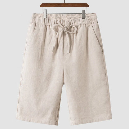 Men's beige linen casual shorts with a loose fit and elastic waistband on a neutral background.