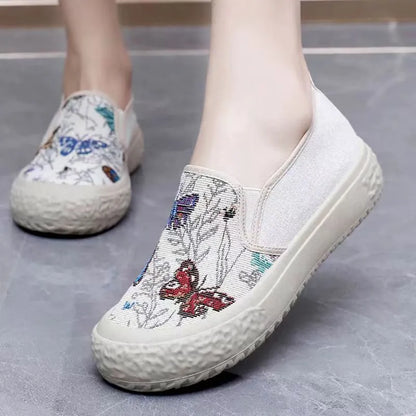 Women's black and white slip-on canvas shoes with round toe and decorative stitching