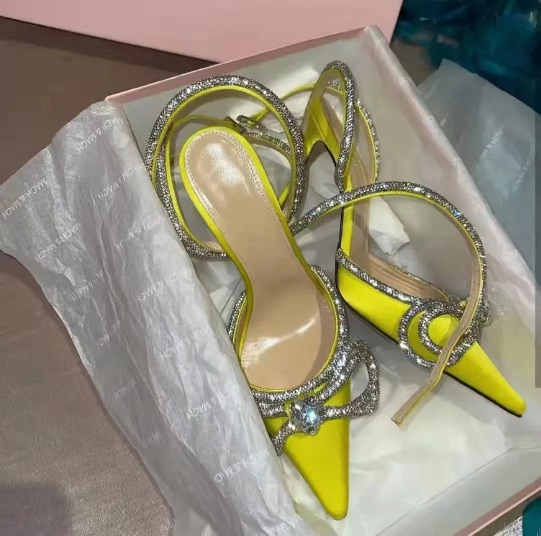 Women's black stiletto heel sandals with silk bandage ankle strap and buckle fastening on a pointed toe.