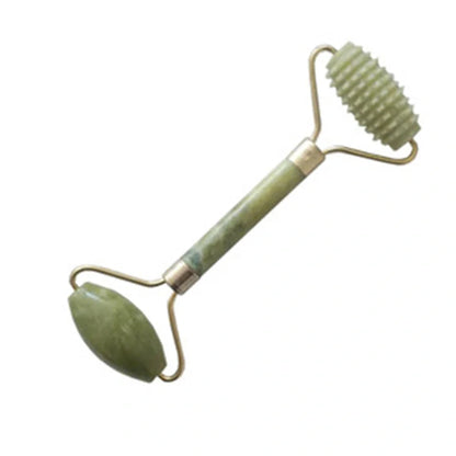 Natural green jade beauty massager with roller and scraper tools on white background