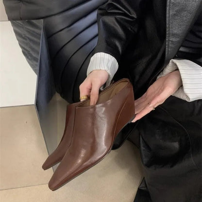 Women's black wind wedge closed toe half slippers showing PU upper and open back.