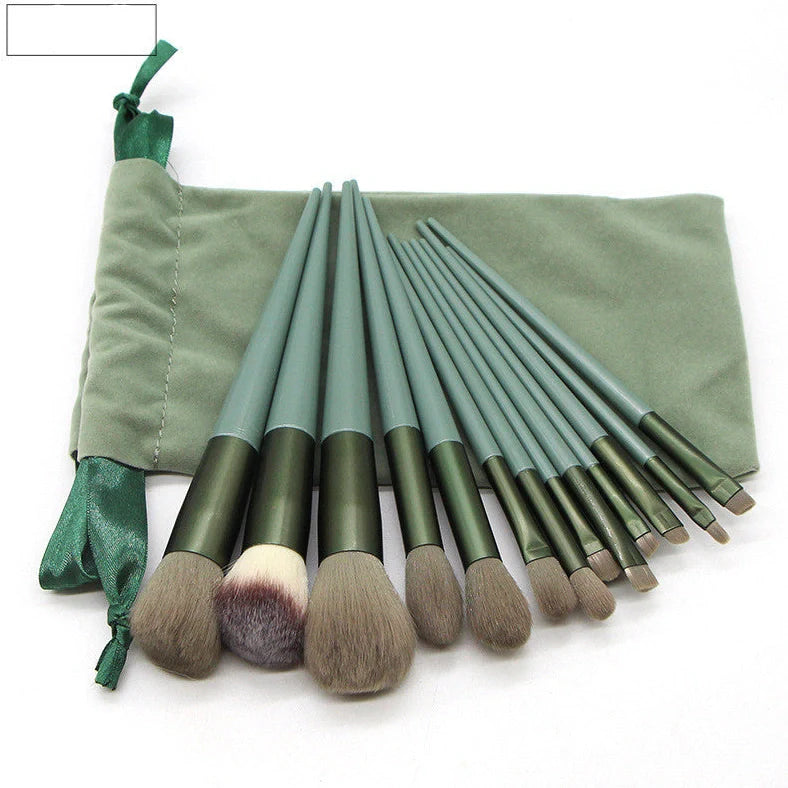 13 green makeup brushes with plastic handles and aluminium ferrules arranged with storage bag