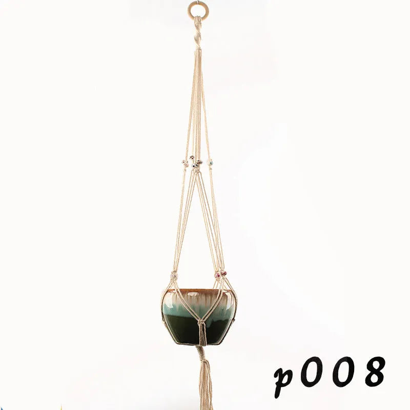 Handwoven natural cotton rope plant hanger cradling a green potted succulent on a wooden table.