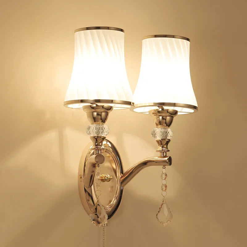 European style wall lamp with glass shade mounted on a wall, showing the cable switch.