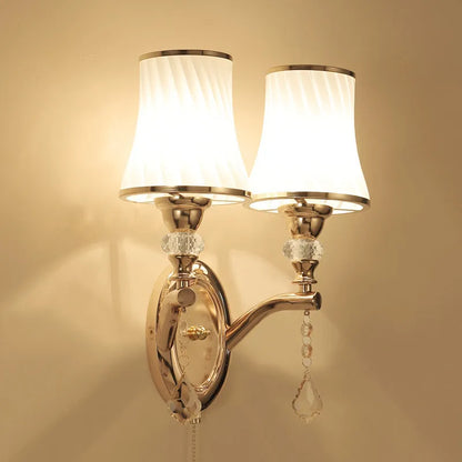 European style wall lamp with glass shade mounted on a wall, showing the cable switch.