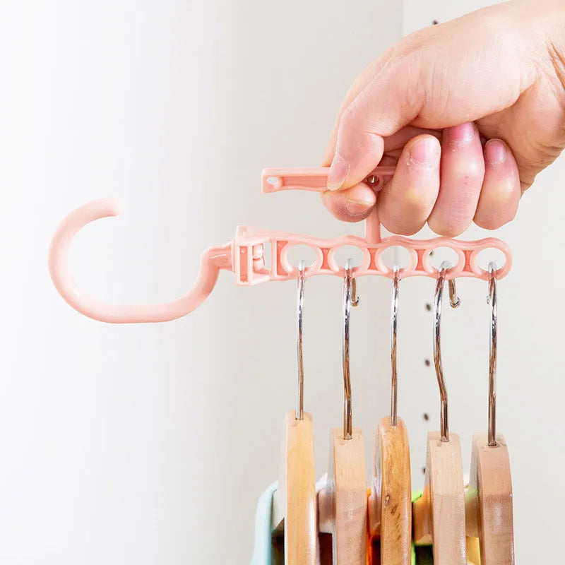 Blue revolving wardrobe hanger with five branches and a handle for multiple garment organisation.