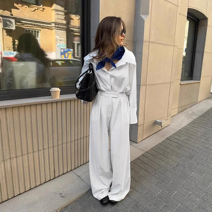 White women's wide-leg trousers with a striped pattern and zip detail, laid flat.