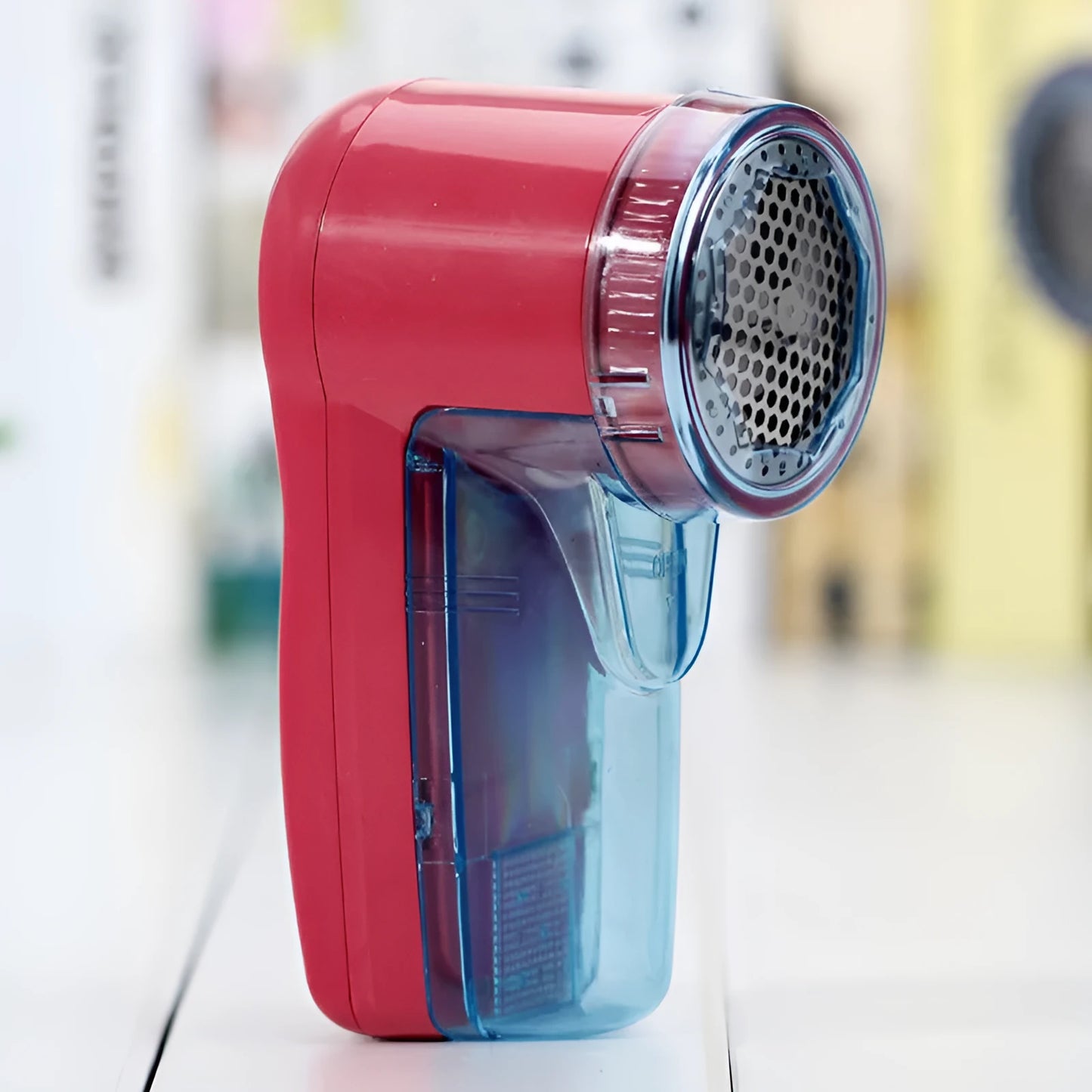 Handheld portable electric lint remover fabric shaver on a blue background.