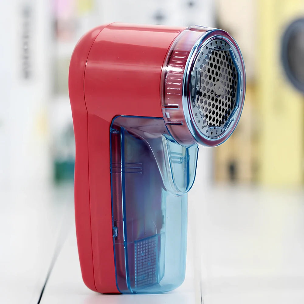 Portable electric lint remover measuring 11x16cm removing bobbles from blue woollen jumper