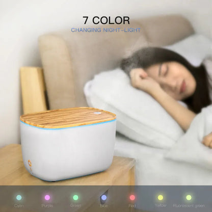 GX-22K white ultrasonic humidifier and aromatherapy diffuser unit with night light on a wooden surface.