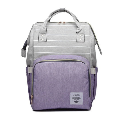 Stylish maternity diaper bag in various colors, featuring a paper bag design, separate bottle compartment, and discreet breastfeeding button.