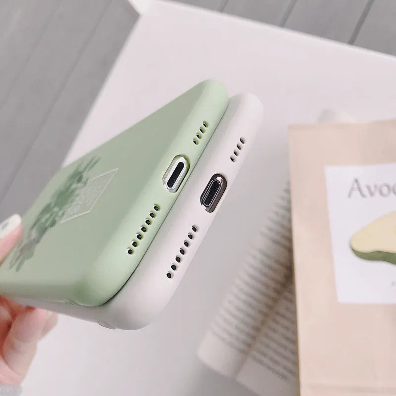 White silicone iPhone case with a painted green leaf plant design on the back.