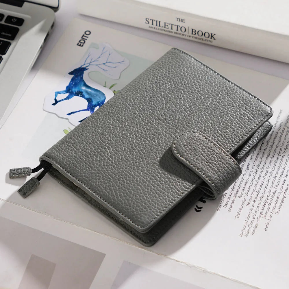 Close-up of a hand-embossed lychee pattern on an off-white A6 cowhide leather notebook with loose-leaf binding.