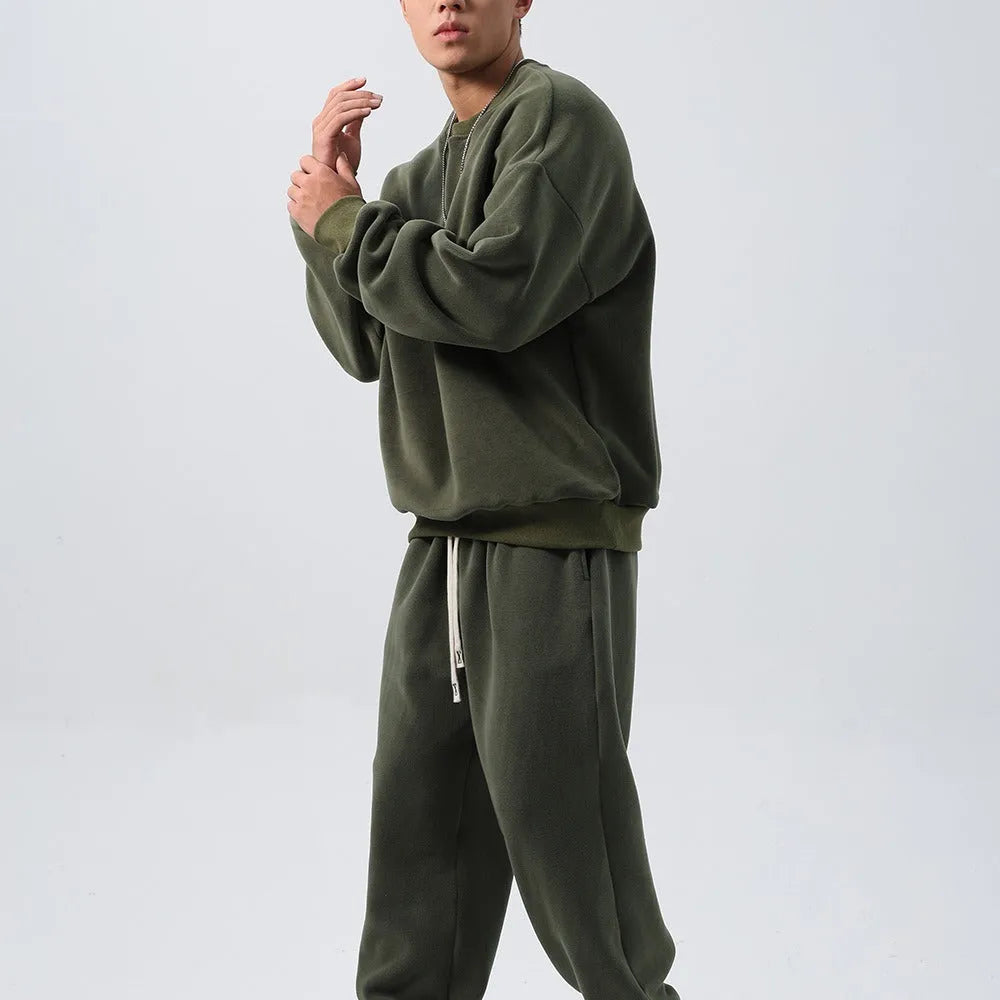 Man wearing a loose-fit army green polar fleece jacket and matching padded trousers from a winter tracksuit set.