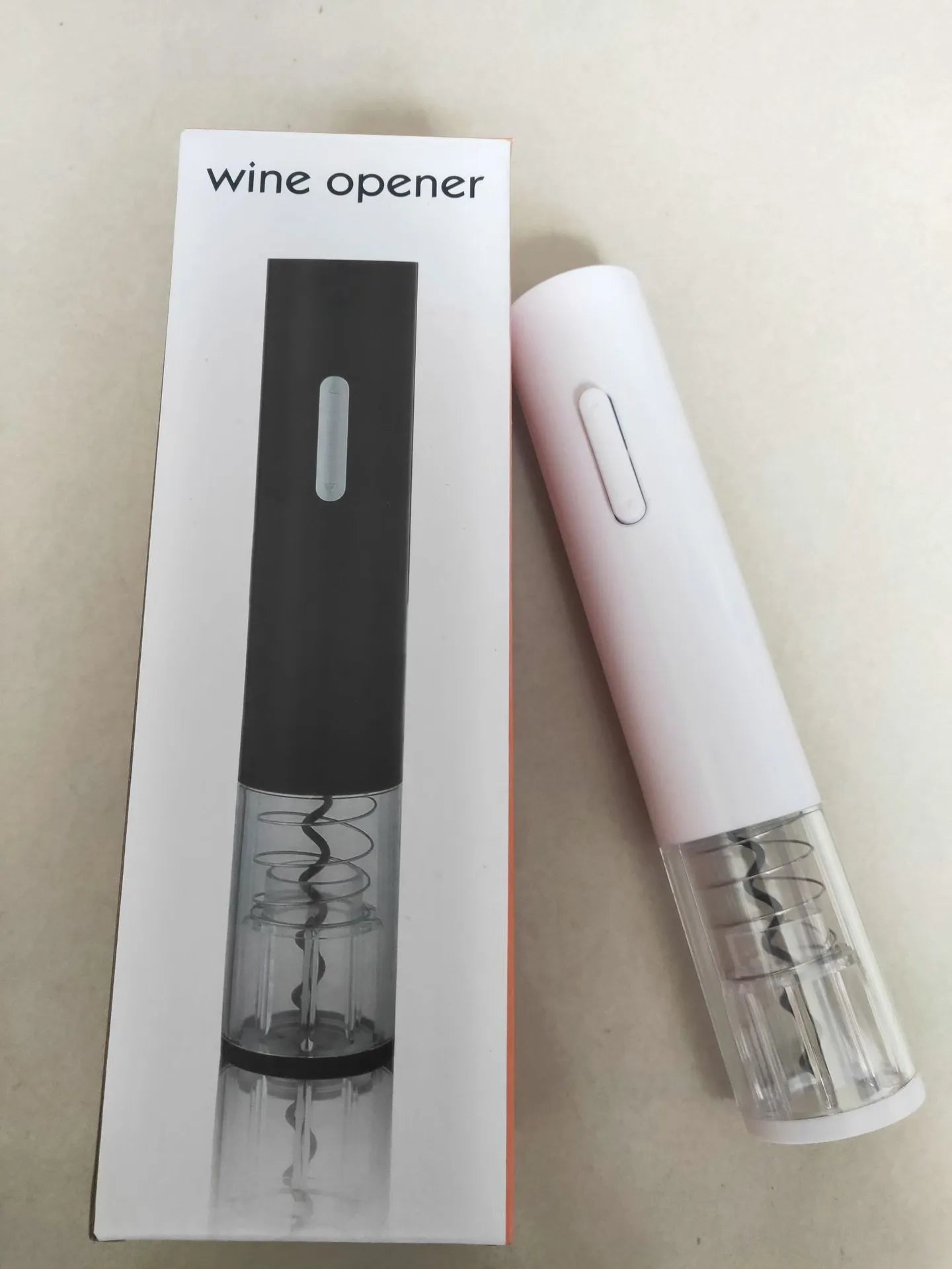 Black automatic electric wine opener with foil cutter showing battery compartment and cork removal mechanism