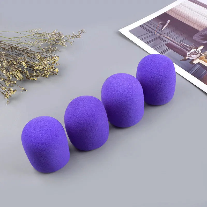 Four foam microphone wind shields in different colours for handheld stage microphones
