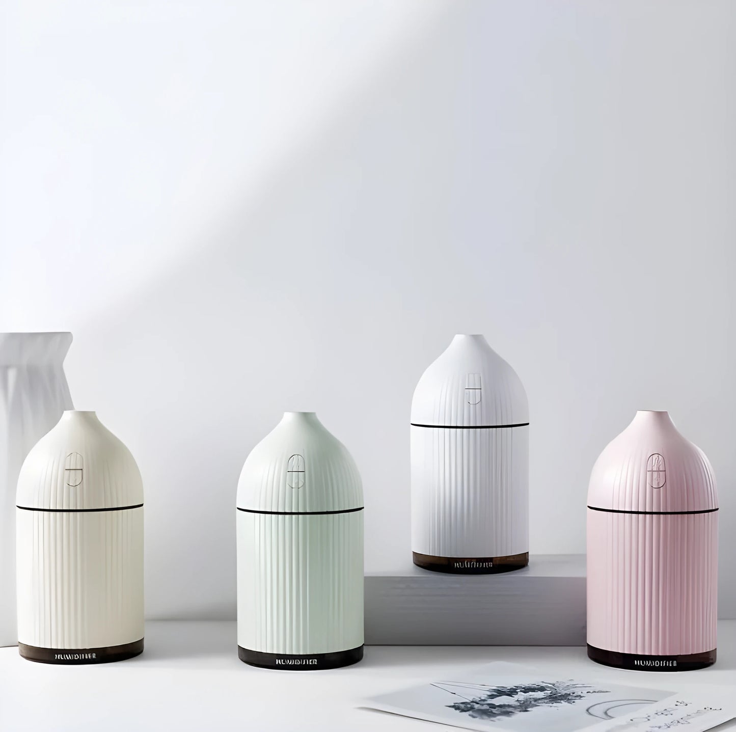 White ultrasonic aromatherapy diffuser and air humidifier with LED light, 300ml capacity, on a desk.