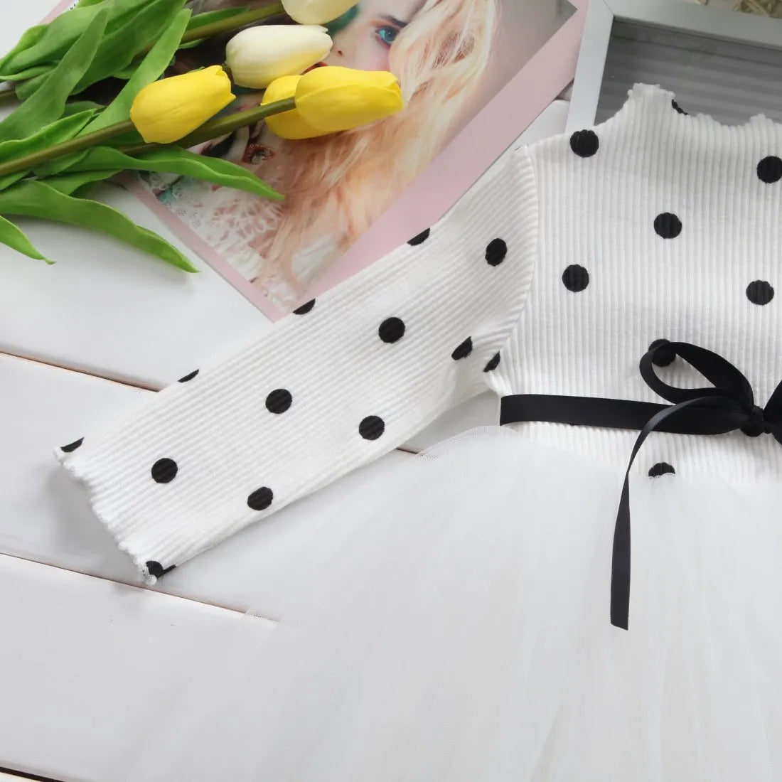 Baby girl wearing a long sleeve black tutu dress with lace detail for a birthday party.