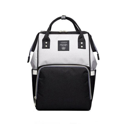 Stylish maternity diaper bag in various colors, featuring a paper bag design, separate bottle compartment, and discreet breastfeeding button.