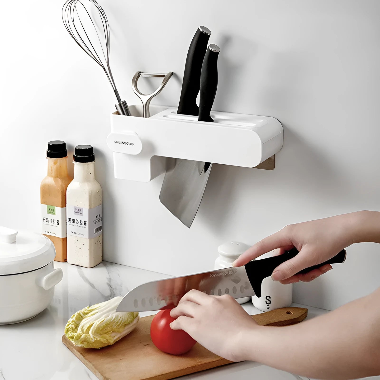 White modern plastic knife block holding six kitchen knives on a countertop.