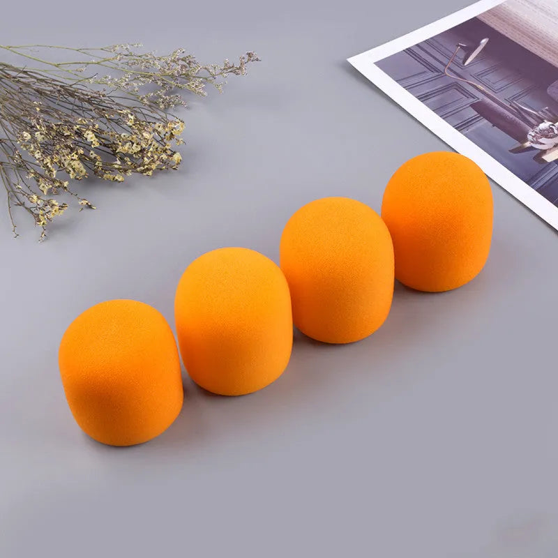 Four foam microphone wind shields in different colours for handheld stage microphones