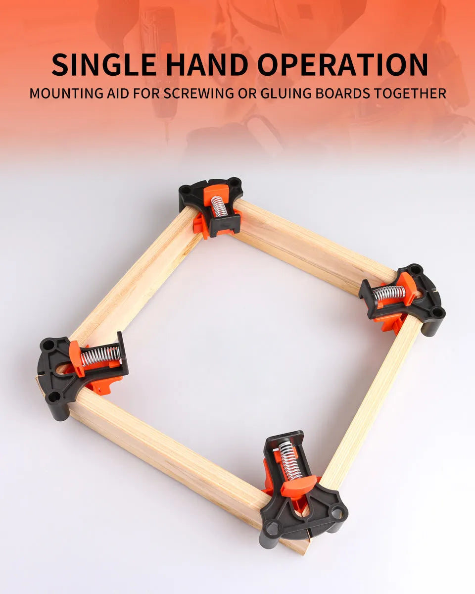 Four white plastic right angle clamps for woodworking and picture frame assembly on a workbench.