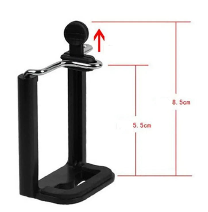 Black mini camera tripod with extended legs and a separate U-shaped universal phone clip on a table.