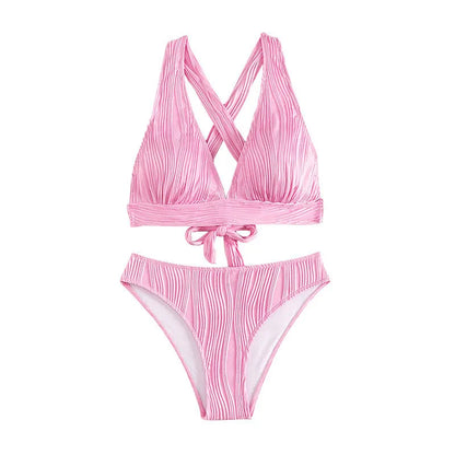 Pink and black women's halter strap bikini with split shorts on a white background