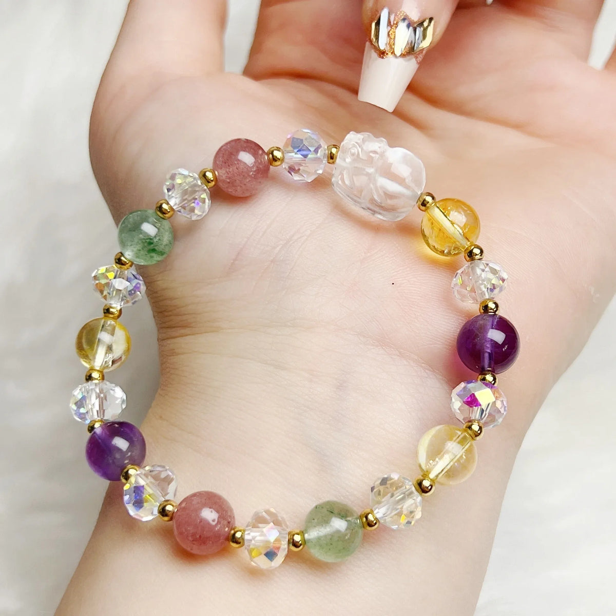 Close-up of a handmade crystal bracelet with a detailed nine-tailed fox design on a wrist.