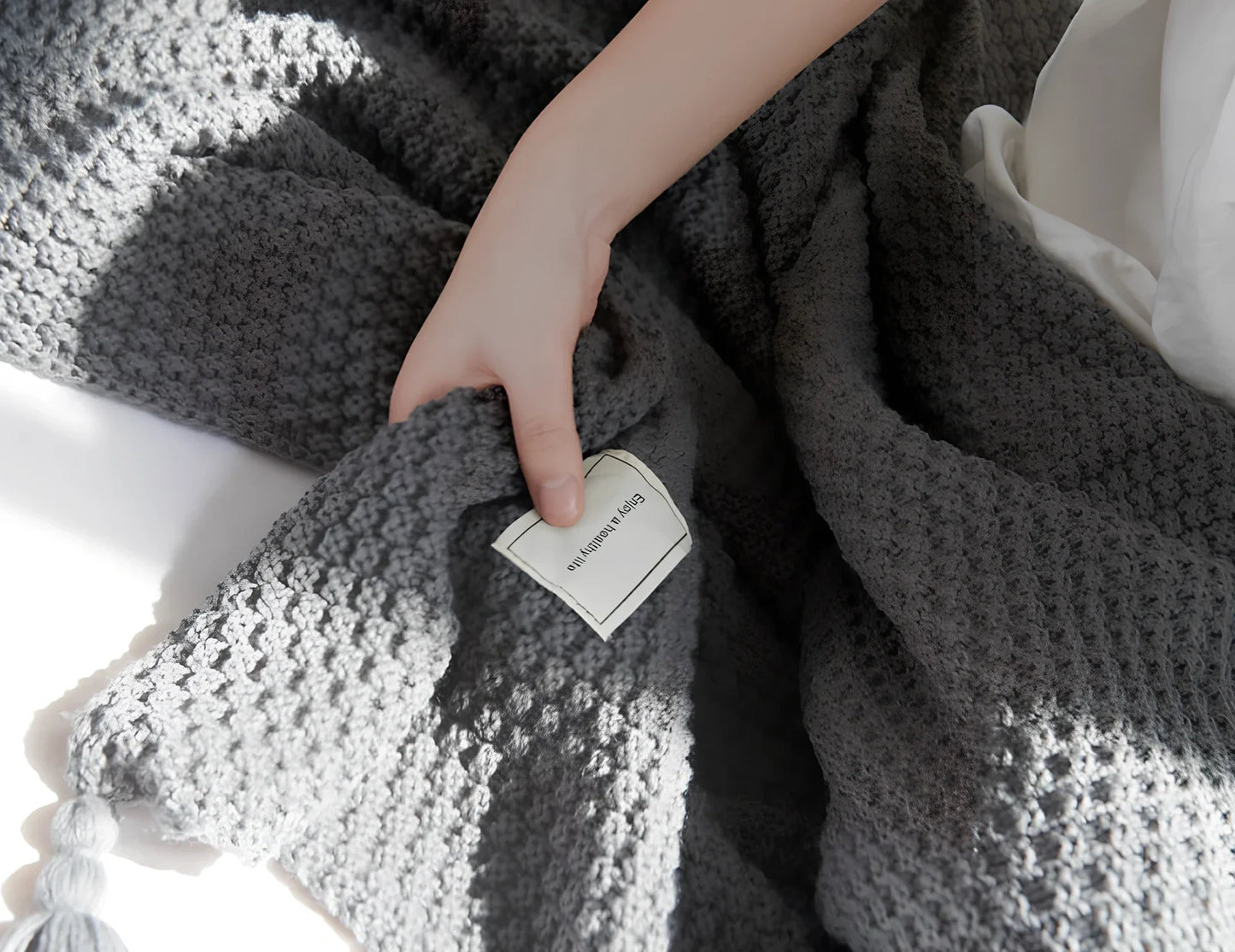 Fringed knitting blanket in beige colour showing 5cm fringe detailing and dense acrylic weave texture