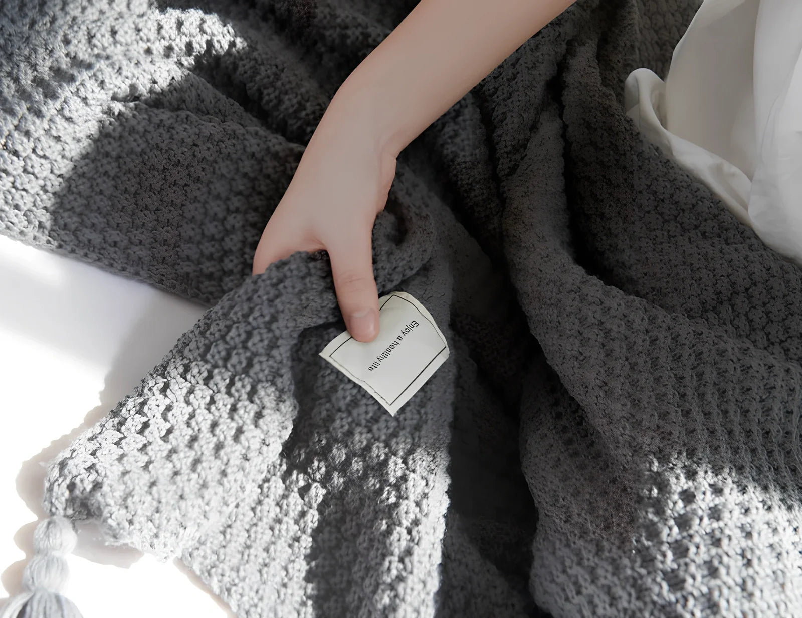 Fringed knitting blanket in beige colour showing 5cm fringe detailing and dense acrylic weave texture