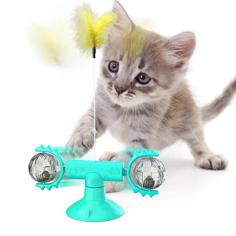 Cat playing with rotating windmill toy featuring luminous balls and suction base