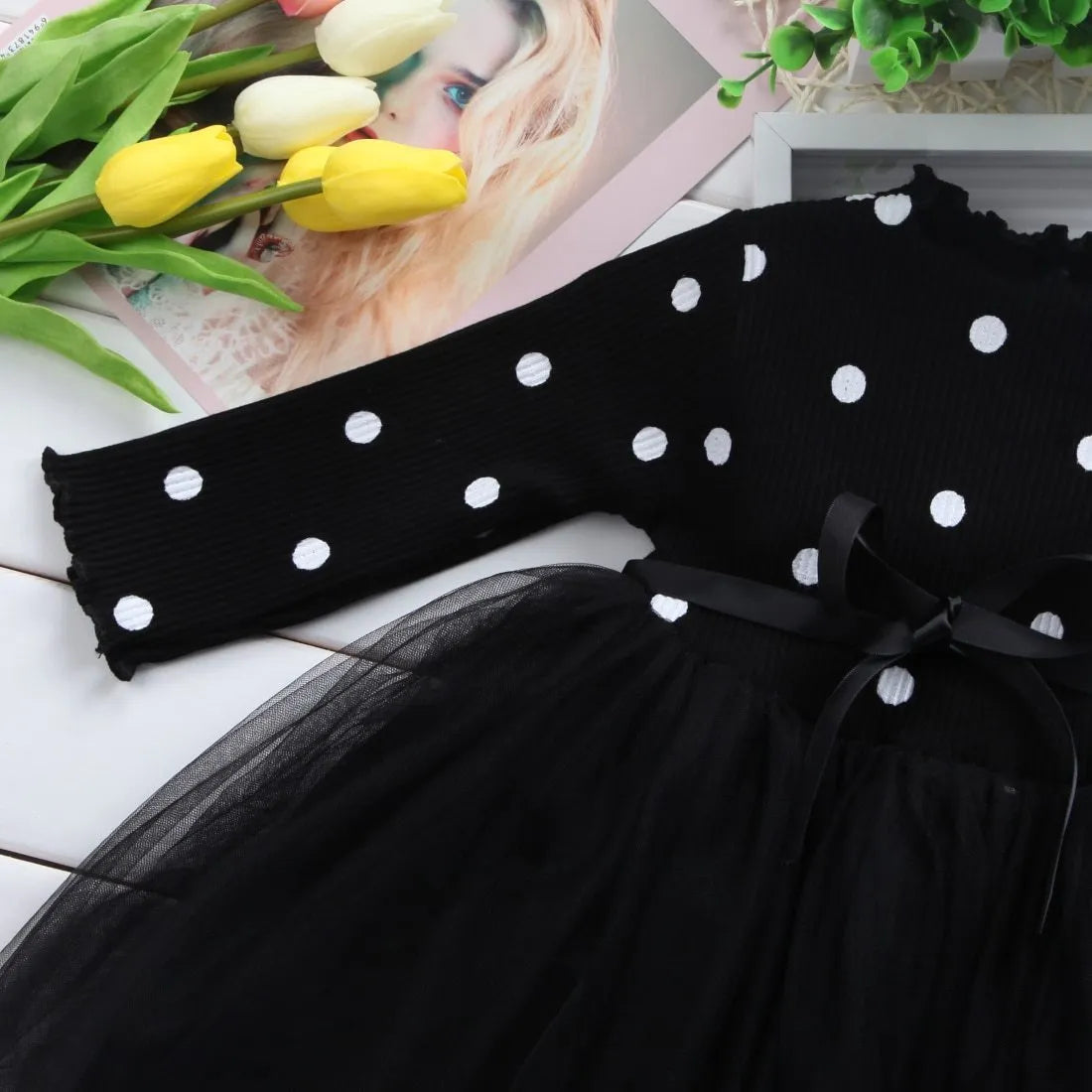 Baby girl wearing a long sleeve black tutu dress with lace detail for a birthday party.