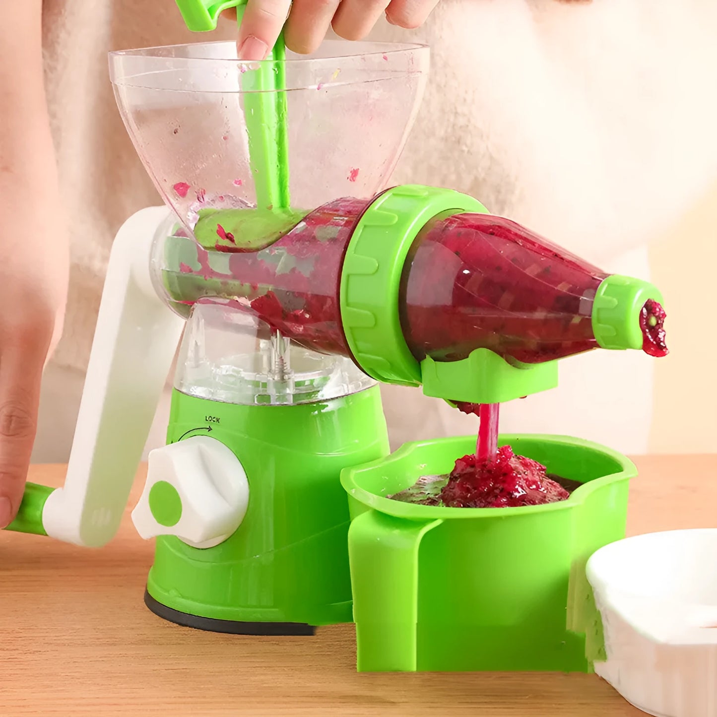 Red manual plastic citrus juicer with a labour-saving lever on a kitchen counter.