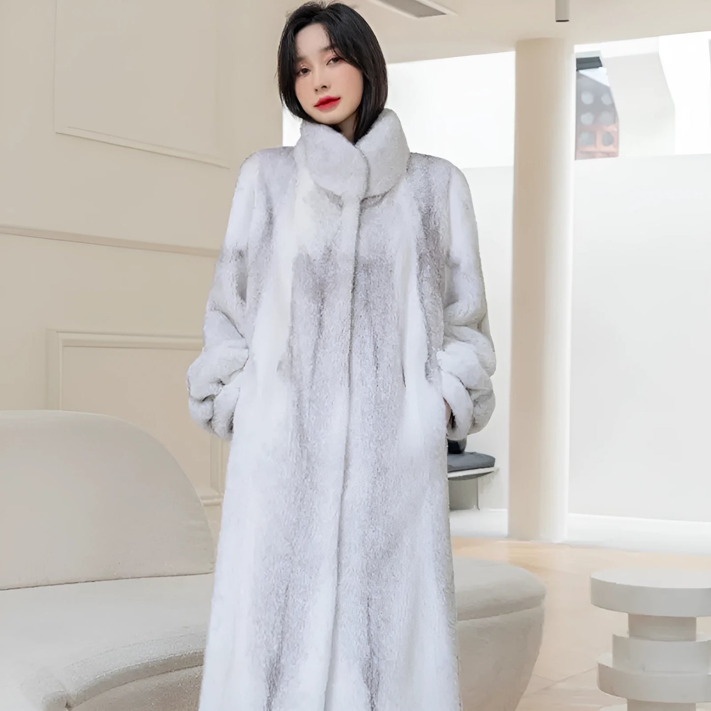 White faux fur women's winter coat with stand-up collar on a hanger
