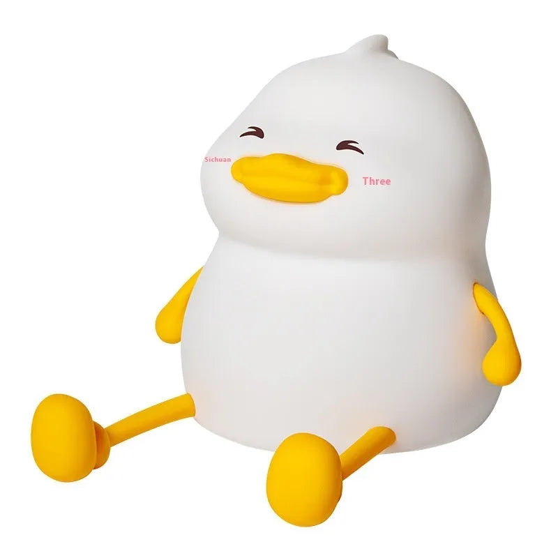 Chubby silicone night light with phone in holder, showing soft white glow and compact size.