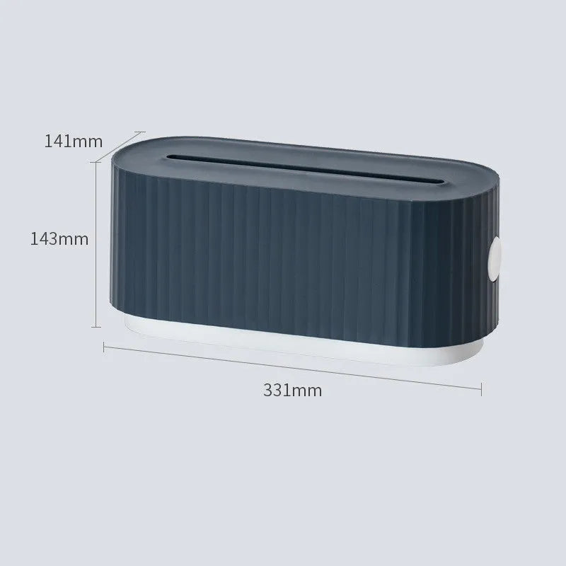 Blue desktop cable storage box with a white lid, showing cable ports on the base and a mobile phone sitting in its slot on top.